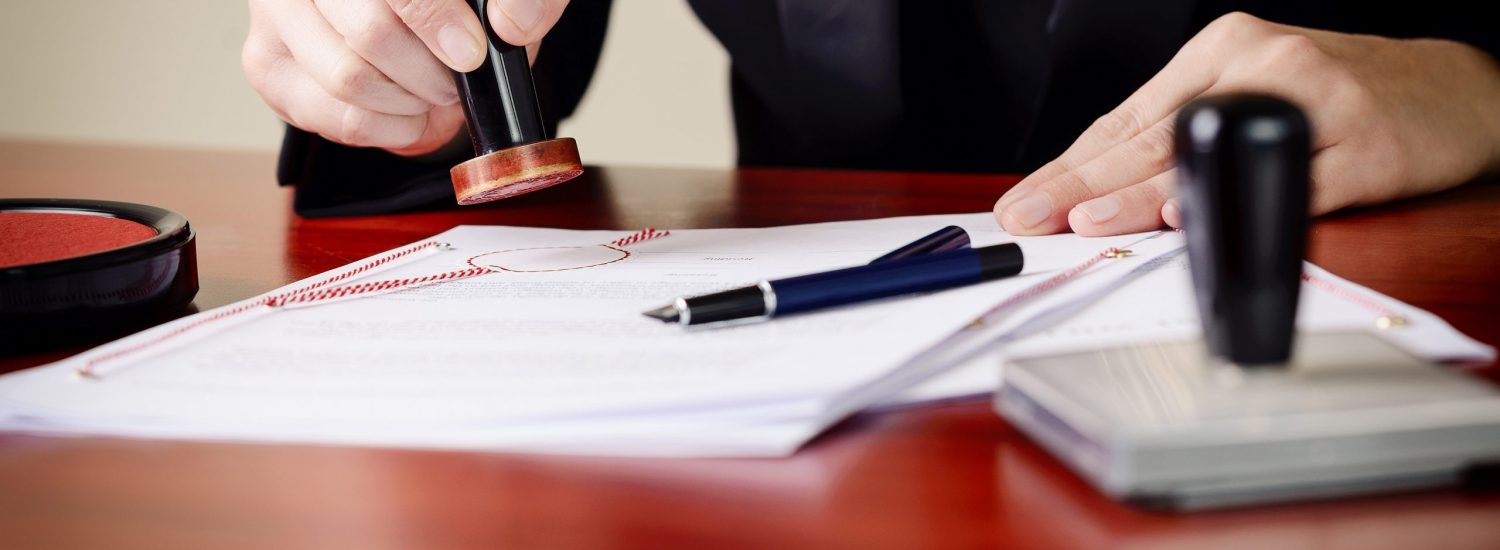 Closeup on notary's public hands stamping document. Closeup on notary's public hands stamping document. Notary public accessories