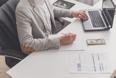 A male accountant works at a pc in an office at home. Payroll and cash withdrawal